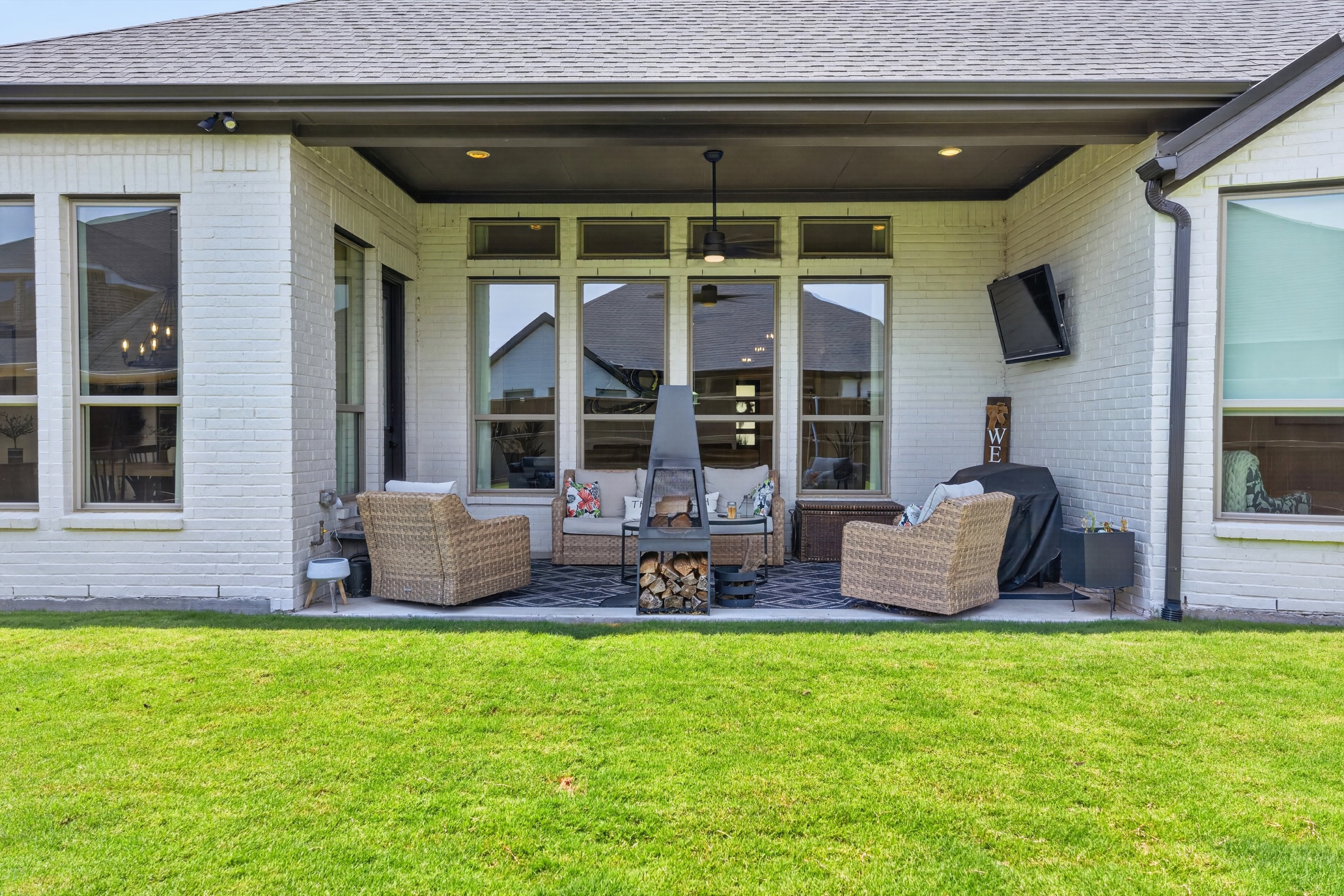 Covered patio overlooking a green backyard